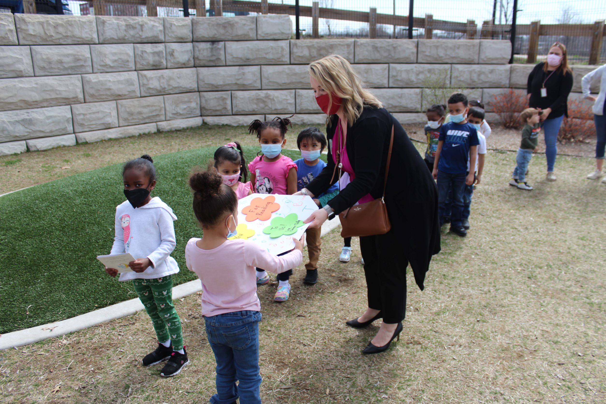 Carolyn Balicki, Assistant Vice President/Retail Banking Officer and Wilbraham Branch Manager of Monson Savings Bank, receives a special card handmade by the Educare Springfield students, following hearing the wonderful story of “Little Frog and the Bright Lights”. A copy of the book and a piggy bank was given to each child.