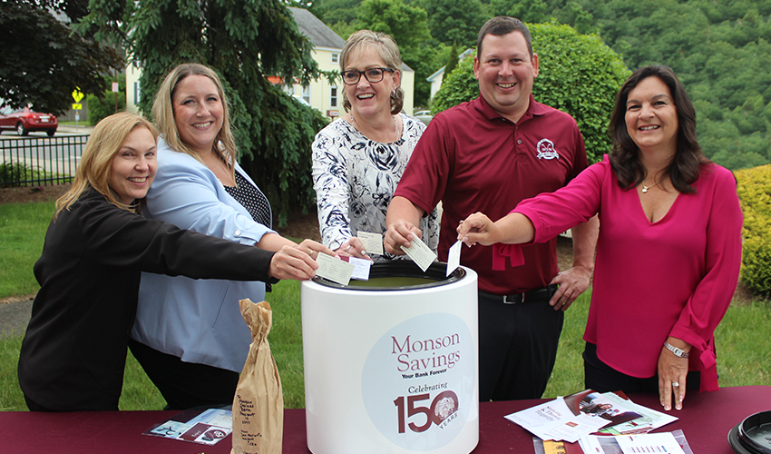 Monson Savings Bank Vice President Darlene Mark, Assistant Vice President Kylie LaPlante, Senior Vice President Nancy Dahlen, Senior Vice President Rob Chateauneuf, and Vice President Lena Buteau place their business cards into the time capsule at the ceremony.