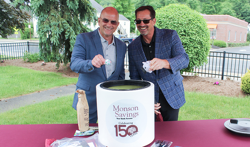 Monson Savings Bank President and CEO Dan Moriarty along with Executive Vice President and Chief Operating Officer Michael Rouette add a golf ball and piggy bank into the time capsule.