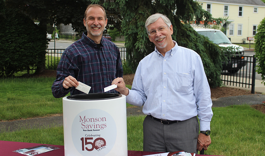 Vice President Kevin Hicks and Vice President Jack Hibbard add their business cards and some brochures to the time capsule.